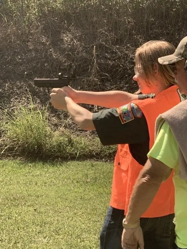 A group of people standing around holding guns.