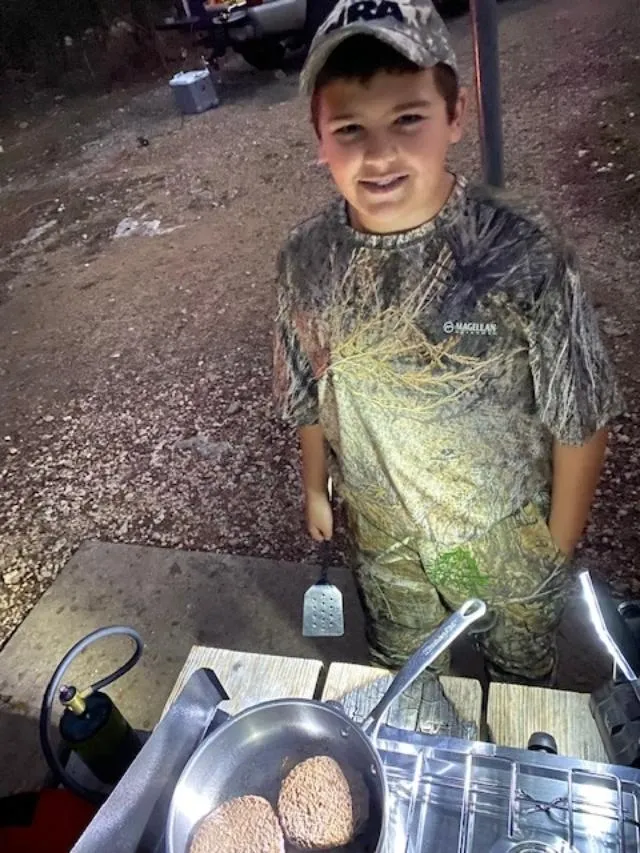 A young boy standing next to a sink.