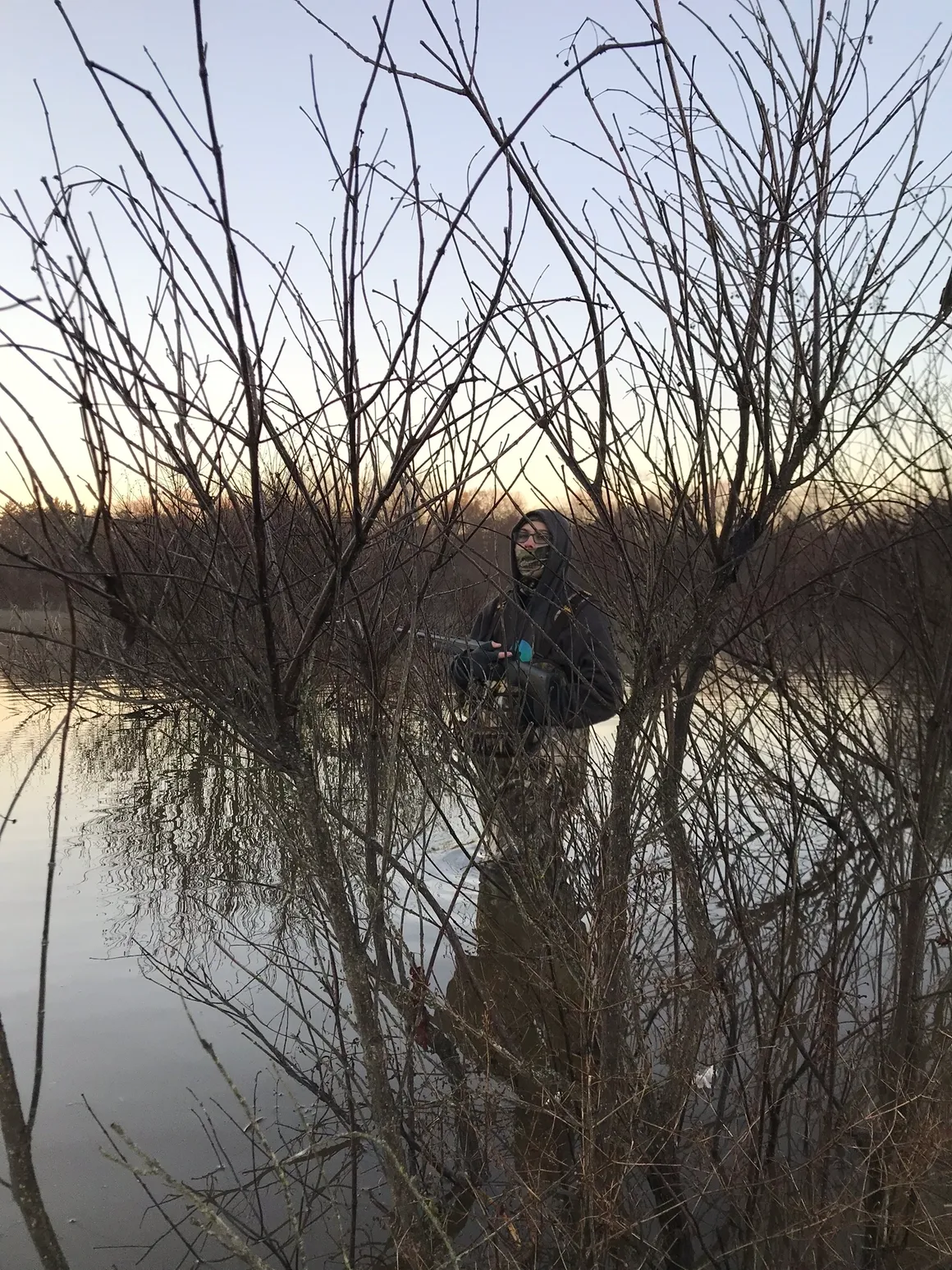 A man standing in the water holding a gun.