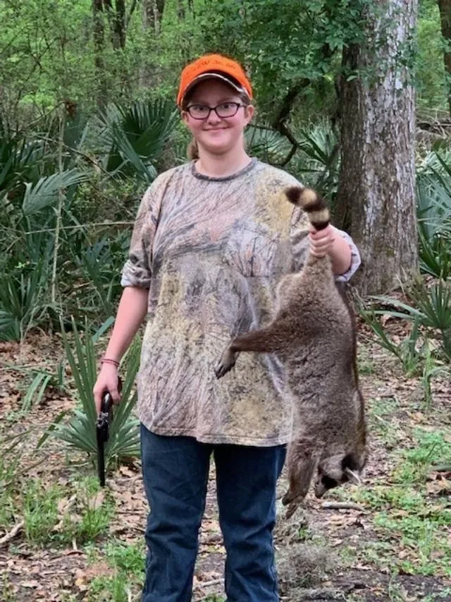 A woman holding an animal in her hand.