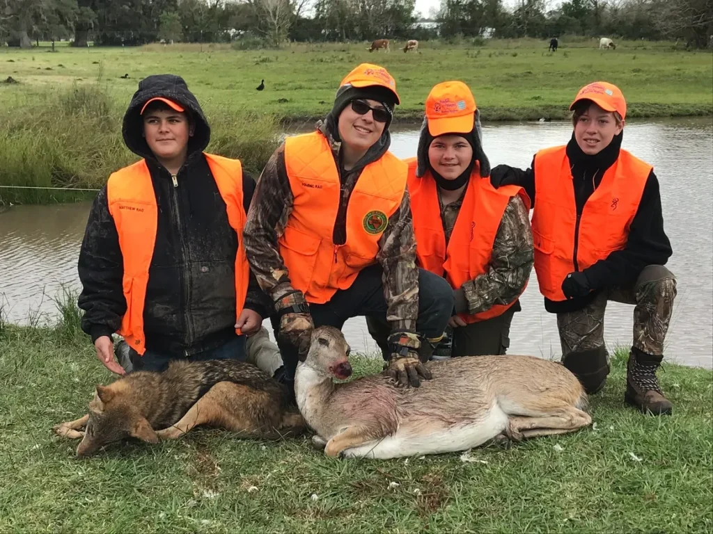 A group of people standing around a dead deer.