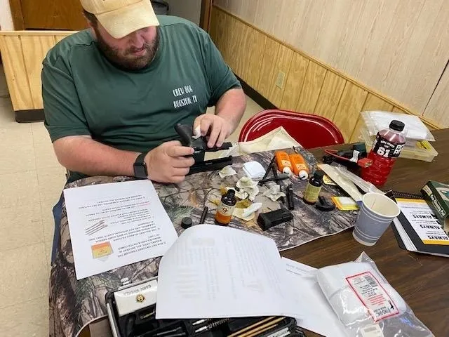 A man sitting at a table with papers and a cell phone.