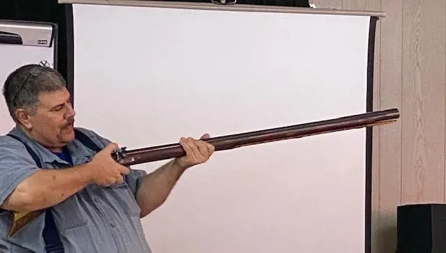 A man holding an old wooden stick in his mouth.