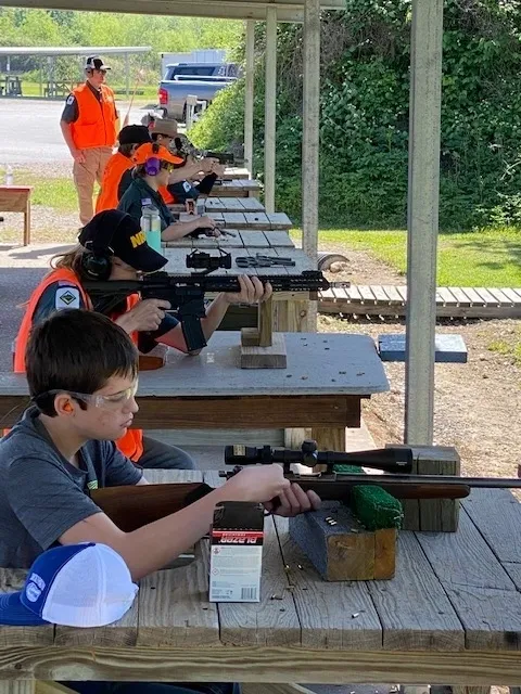 A group of people sitting at tables with guns.