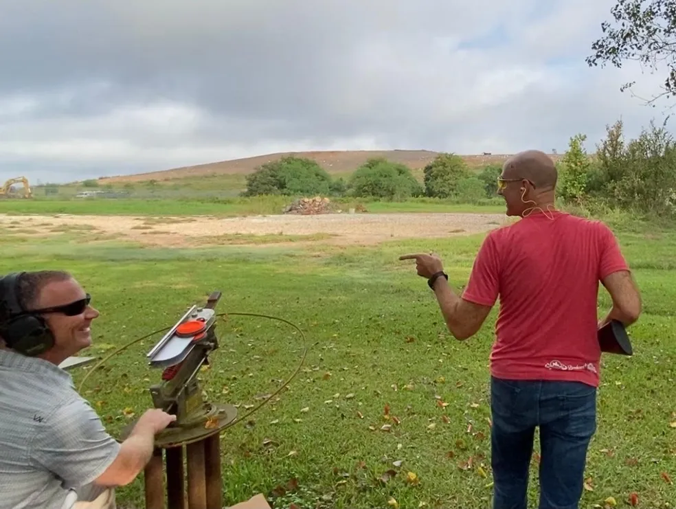 A man pointing at something while another person watches.