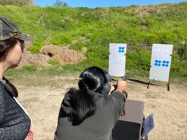 A woman is shooting at an outdoor range.