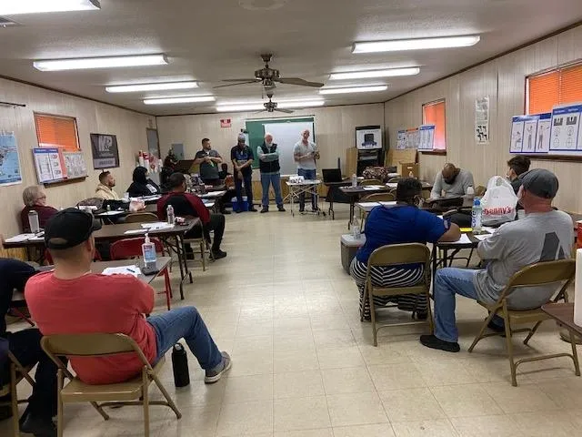 A group of people sitting in chairs around tables.