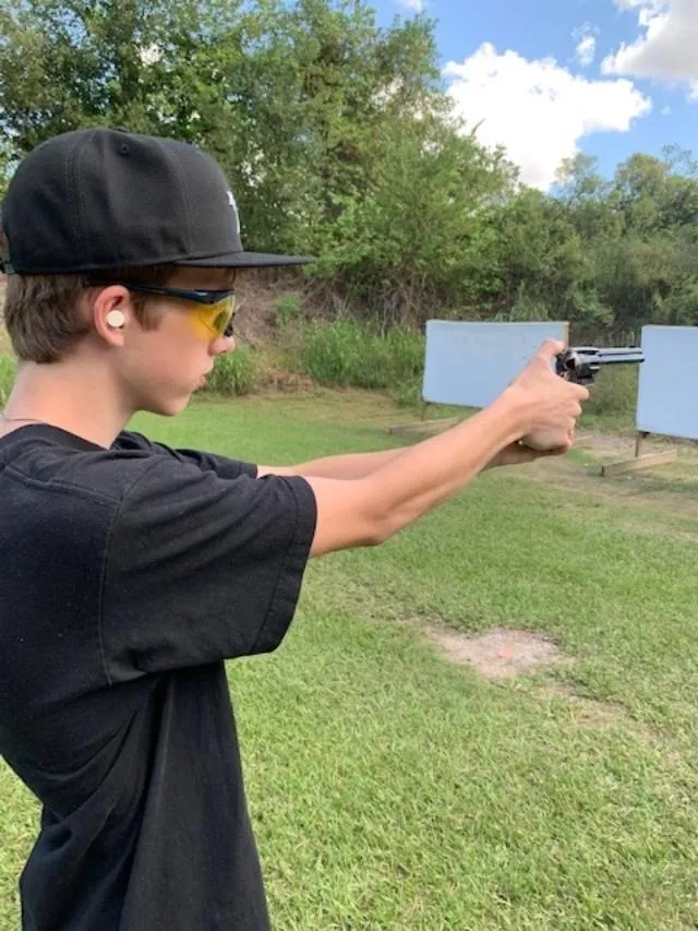 A young man holding a gun in his hand.