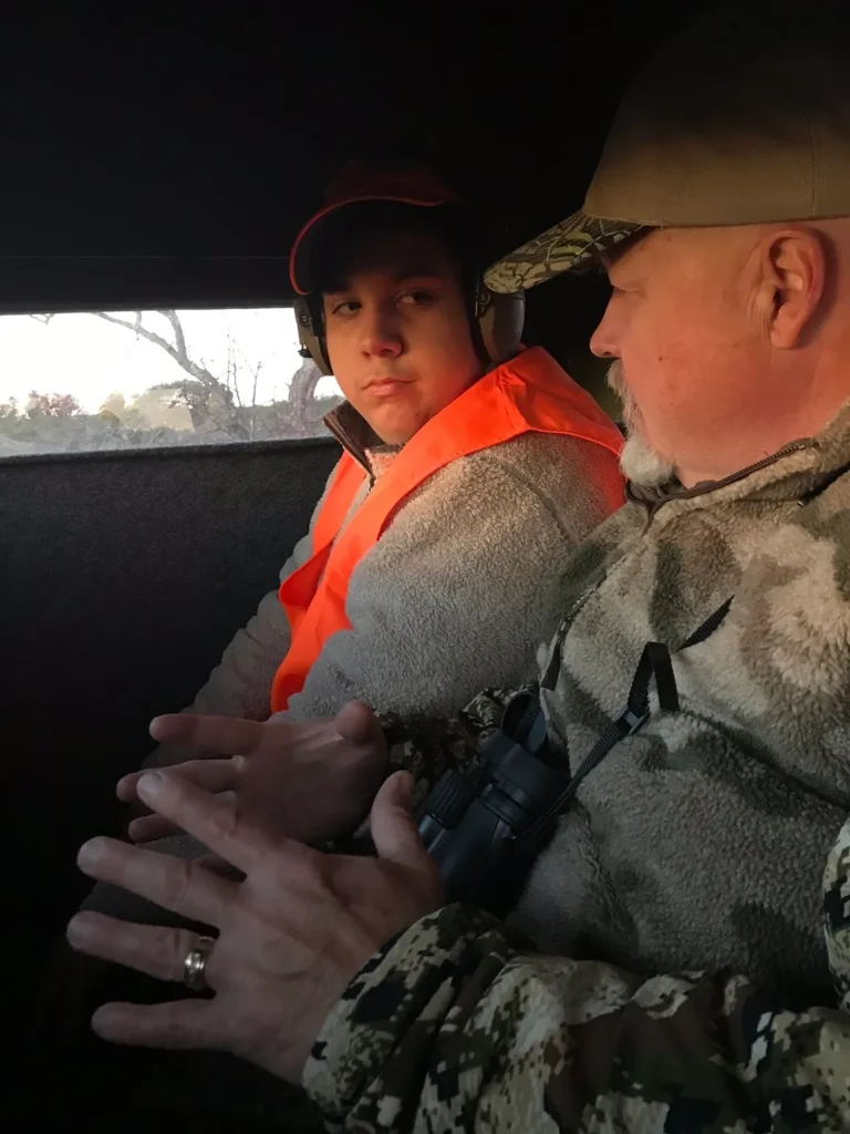 A man and boy in the back of a vehicle.