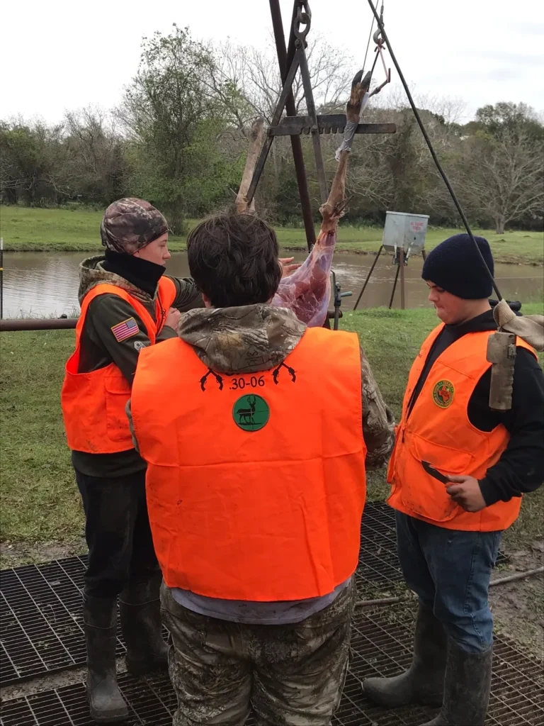 A group of people in orange vests standing around.