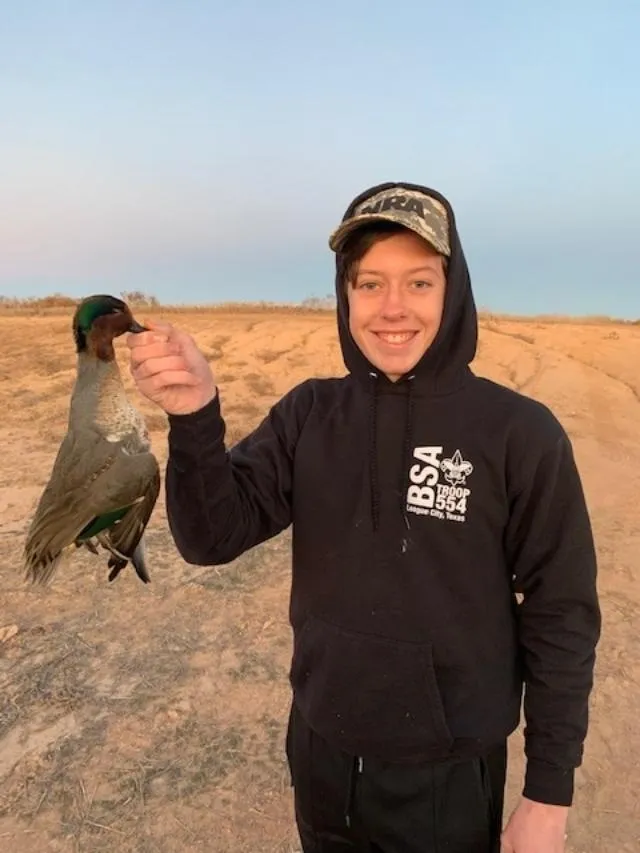 A man holding a bird in his hand.