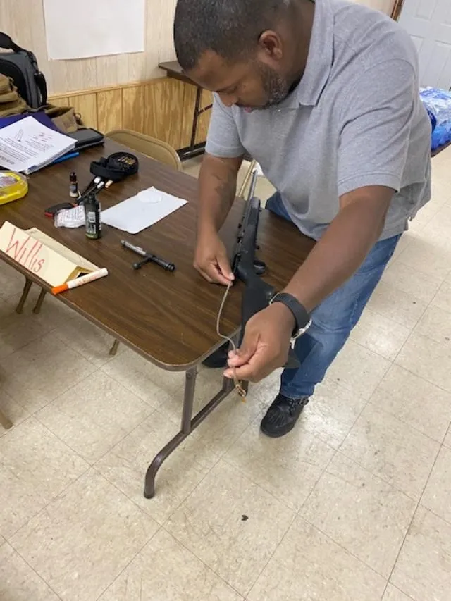 A man is working on an ar-1 5 rifle.