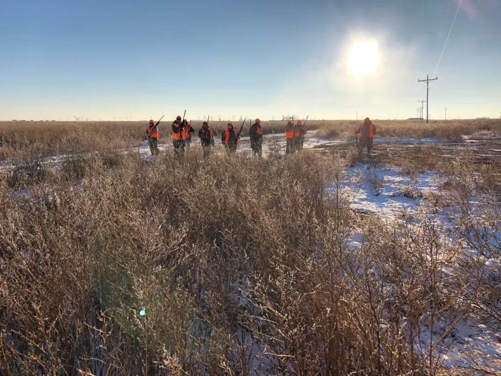 A group of people standing in the grass.