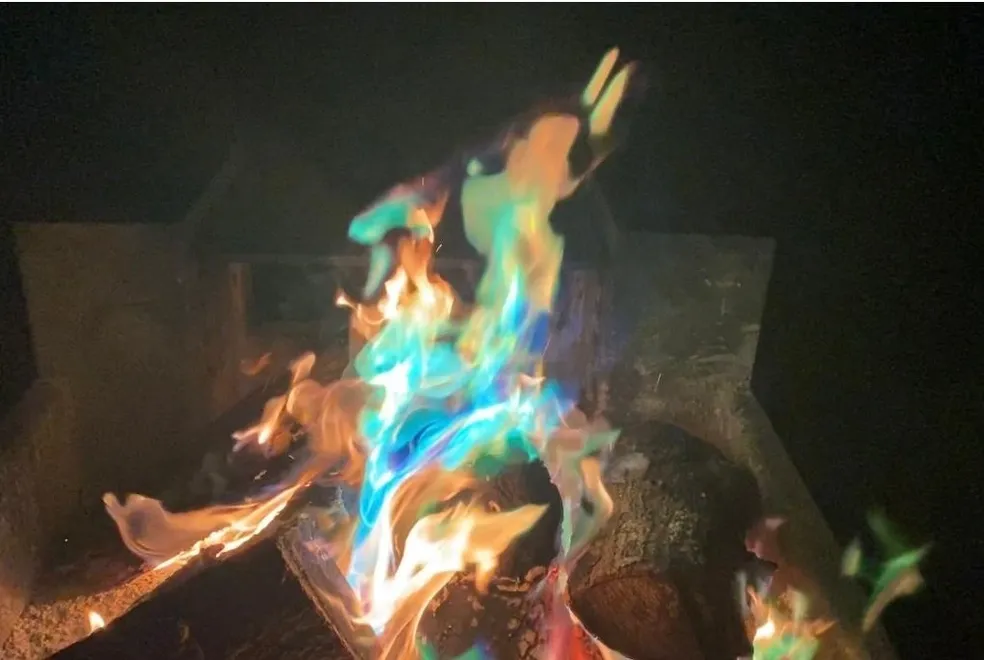 A fire with blue and green flames in the dark.
