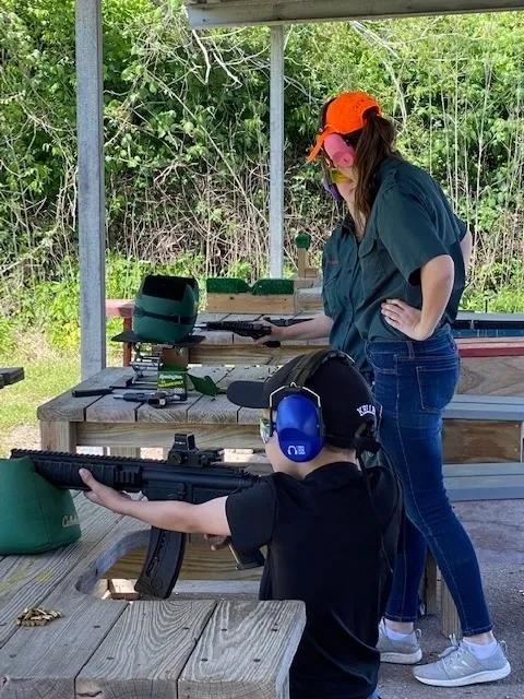 A woman and man are holding guns in their hands.