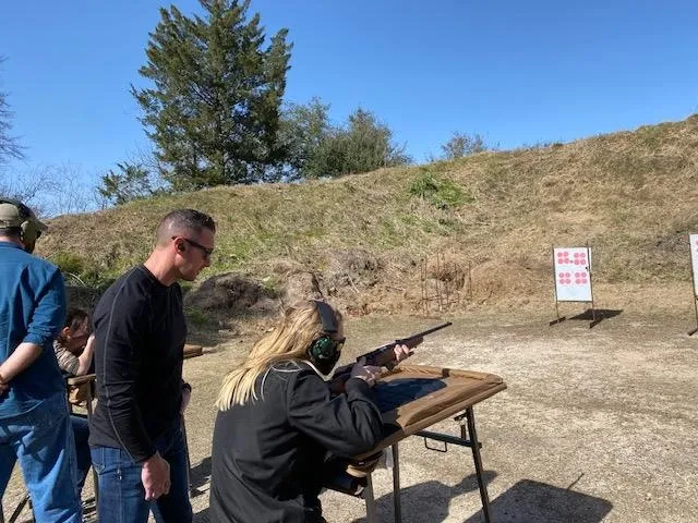 A man and woman are standing at the shooting range.