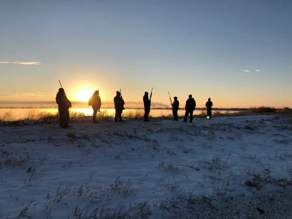 A group of people standing on top of a snow covered slope.