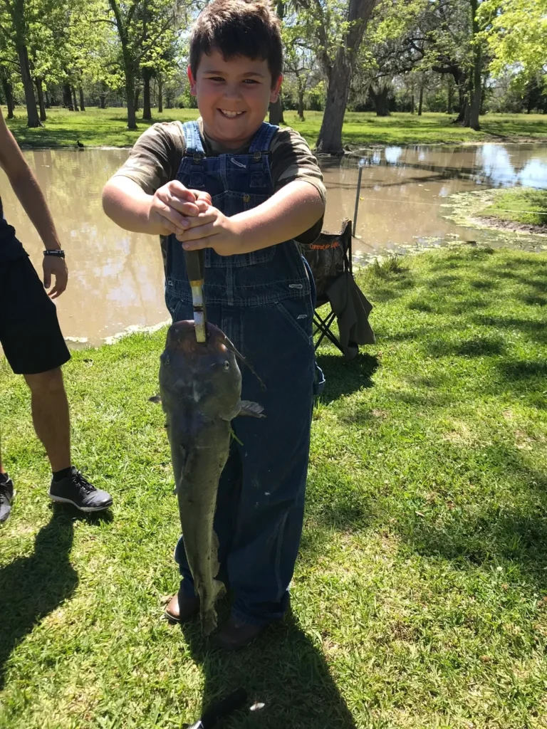 A boy holding a fish in his hands.