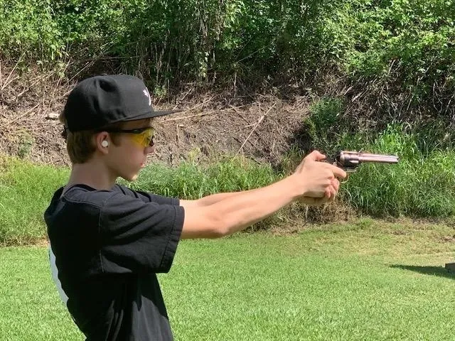 A young man is holding a gun in his hand.