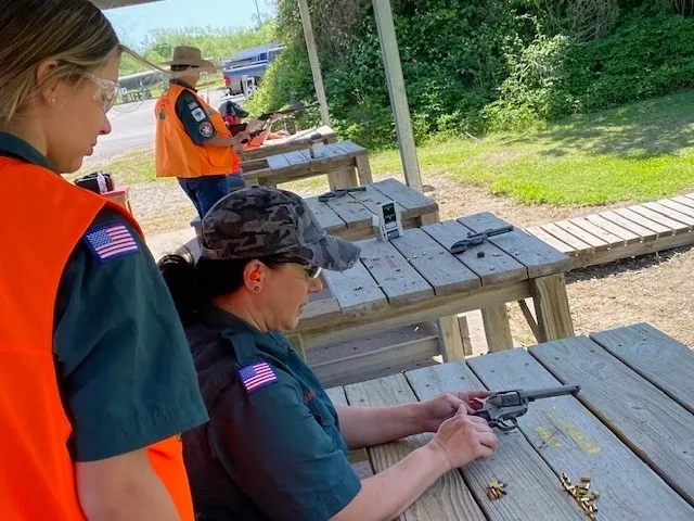 A group of people with guns on a picnic table.