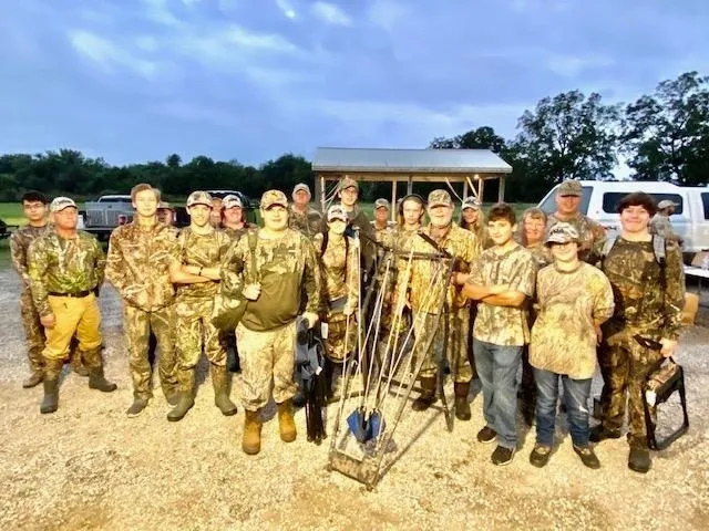 A group of people in camouflage standing next to each other.