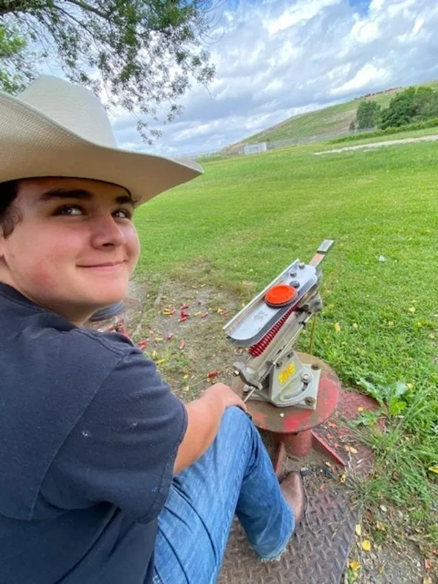 A person sitting on the ground with a hat