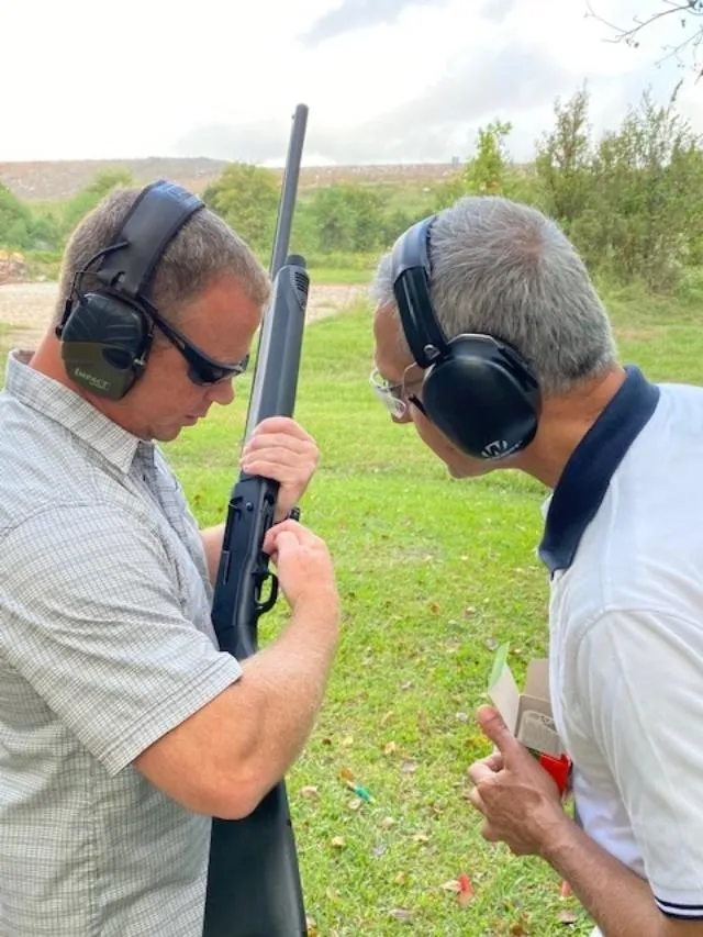 Two men with ear phones and a gun