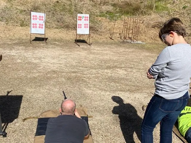A man and woman are practicing shooting at targets.