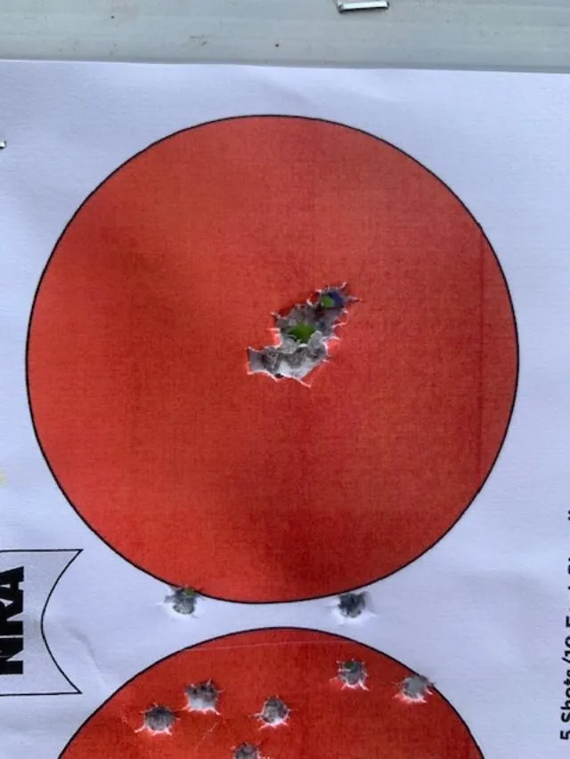 A red target with a bullet hole in it.