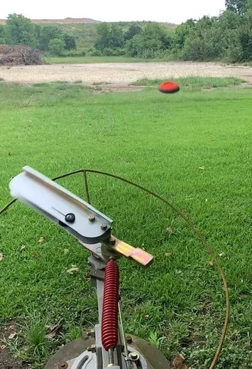 A red frisbee is flying in the air.