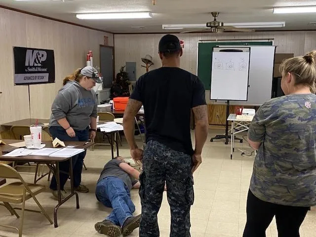 A group of people in the room with some tables