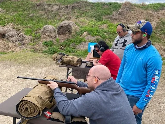 A group of people with guns on top of a hill.