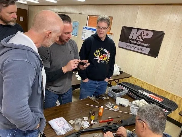 A group of men standing around a table.