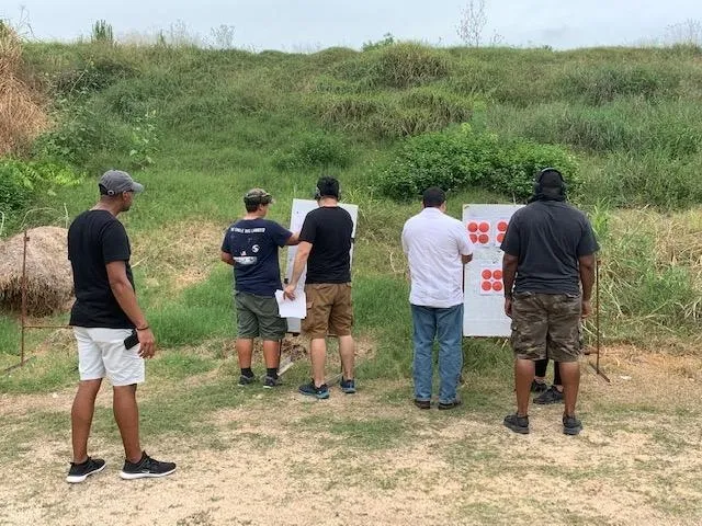 A group of people standing around a sign.