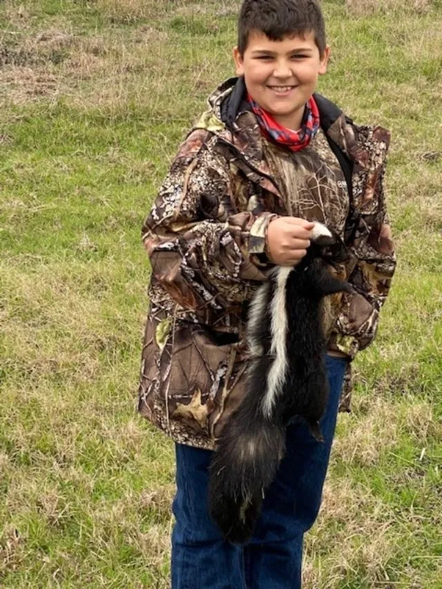 A woman holding an animal in her hand.