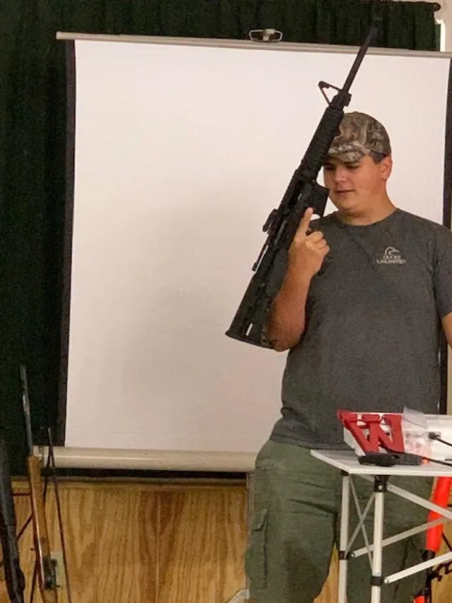 A man holding an ar-1 5 rifle in front of him.