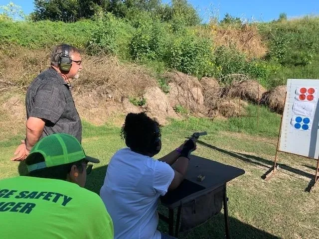 A man is holding a gun while another person watches.