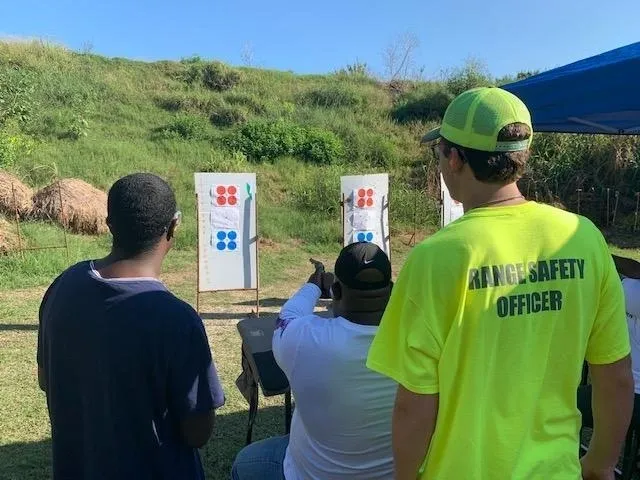A group of people standing around looking at targets.