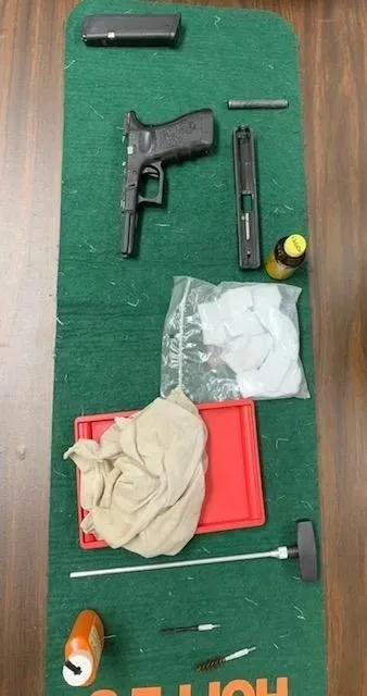 A gun and some other items on the floor.