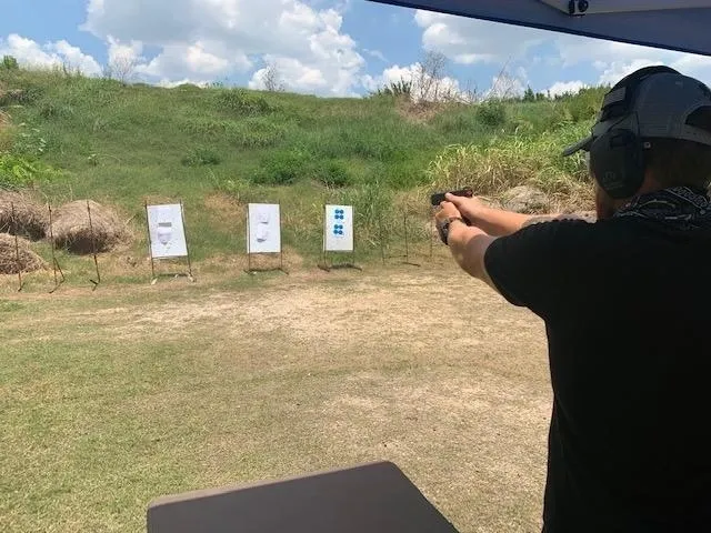 A man is shooting at three targets with his gun.
