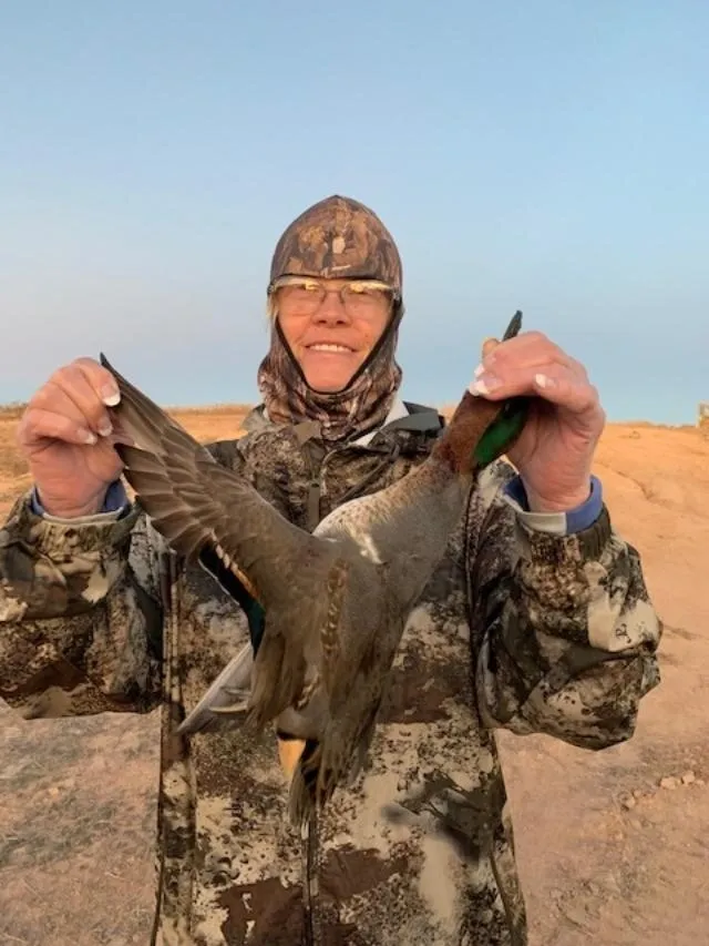 A man holding a duck in his hands.