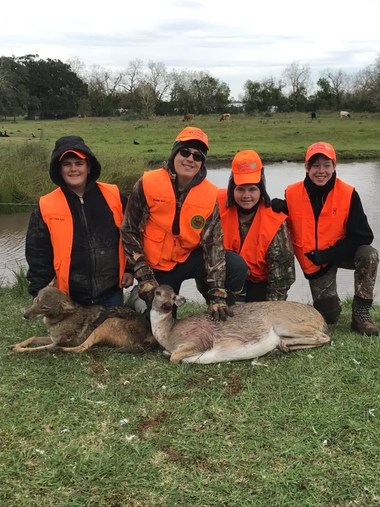 A group of people standing around a deer.