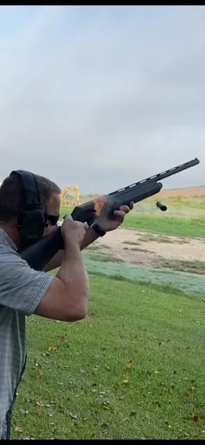 A man is holding a rifle and aiming it.