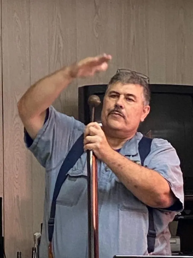 A man holding an old fashioned cane in his hand.