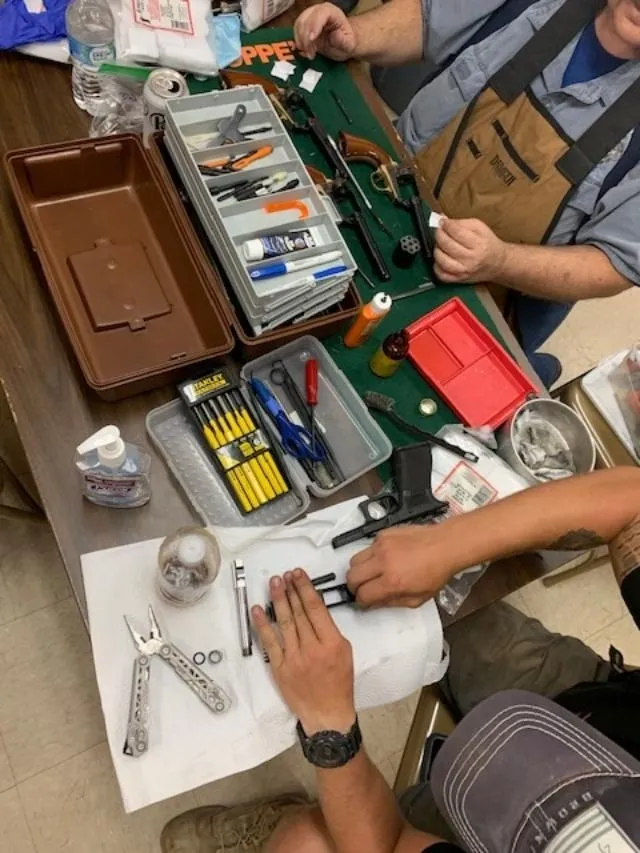A person working on some tools at a table.