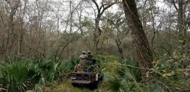 A couple of people riding on the back of an atv.