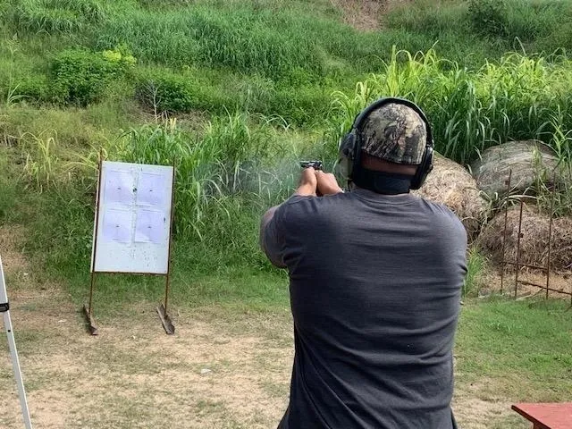 A man is shooting at an outdoor target.