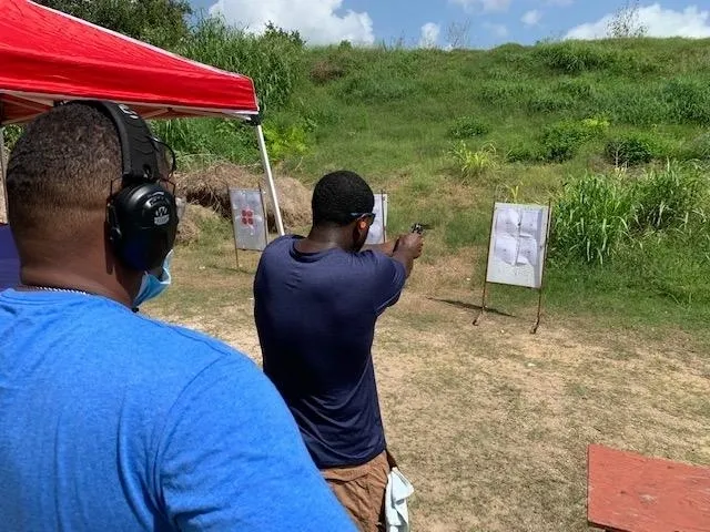 A man is shooting at an event with another person.