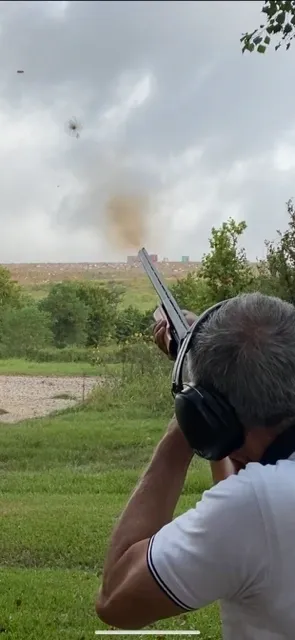 A man with ear phones and headphones is holding a gun