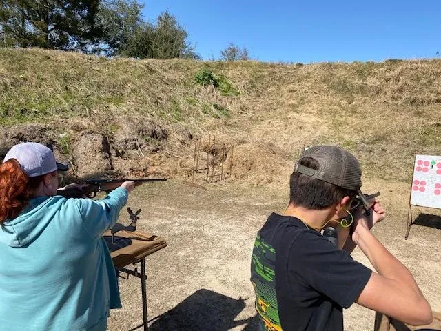 Two people are practicing shooting at a gun range.
